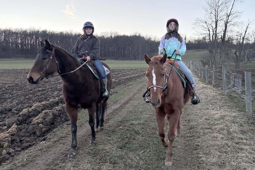 Two girls riding horses